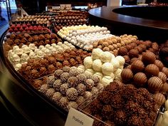 a display case filled with lots of different types of chocolates and candies on top of each other