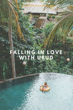 a person floating in an inflatable pool surrounded by trees and greenery with text reading falling in love with ubud