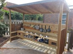 an outdoor kitchen with pots and pans on it