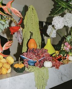 a table topped with lots of different types of fruits and vegetables on top of a counter