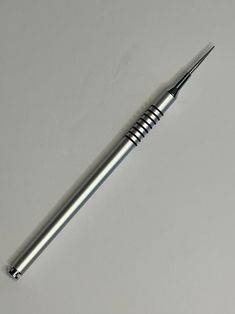 a metal ballpoint pen sitting on top of a table