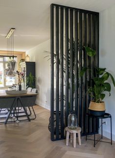 a living room filled with lots of furniture next to a tall black screen divider