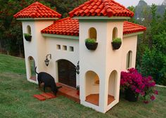 a dog house built into the side of a hill with flowers growing out of it