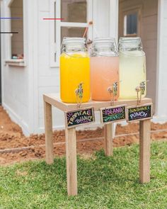 two drinks are sitting on a table with chalkboard signs in front of the house