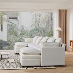 a living room filled with white furniture next to a large glass window covered in trees