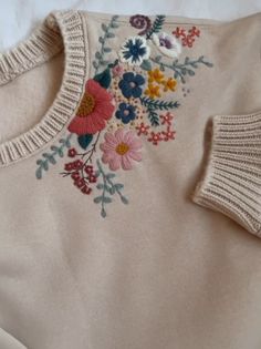 an embroidered sweater with flowers on it