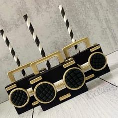 two black and gold radio shaped straw holders