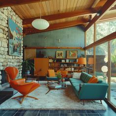 a living room filled with furniture and lots of windows next to a stone wall covered in plants