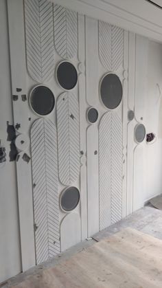 the wall is painted white and has several circles on it, along with holes in the middle