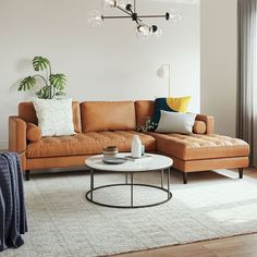 a living room with a couch, chair and coffee table in front of a window