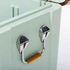 a close up of a metal handle on a green cabinet