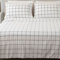 a bed with white and black checkered comforter set on it's side