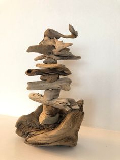 a sculpture made out of driftwood on a white surface with no one around it