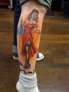 a woman with a bow and arrow tattoo on her leg