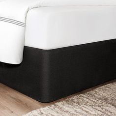 the bed is made with white and black sheets