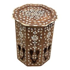 an intricately carved wooden table with white and brown designs on the top, against a white background