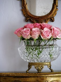 there is a vase with pink roses in it