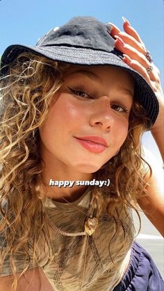 a girl with curly hair wearing a hat