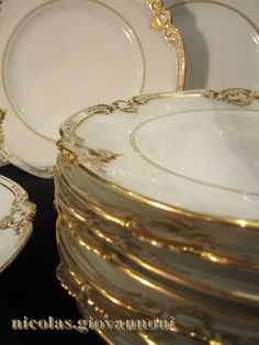 a stack of white and gold plates stacked on top of each other