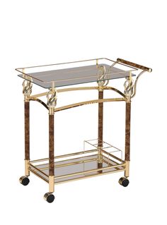 a gold and glass bar cart with wheels on the bottom, in front of a white background