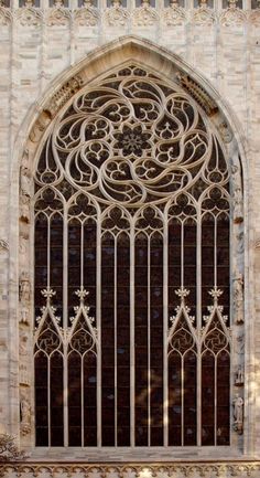 an ornate iron window on the side of a building