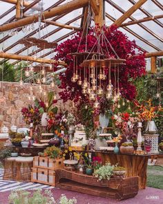 a table with flowers and vases on it in the middle of a garden area