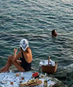 a woman sitting on the edge of a body of water