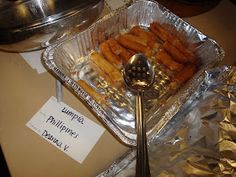 some food is sitting on top of tin foil and next to a silver serving spoon