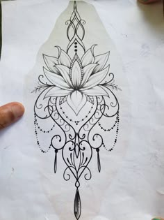 a person holding up a piece of paper with a drawing on it that looks like a flower