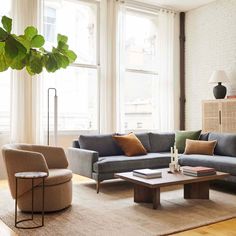 a living room with two couches and a coffee table in front of large windows