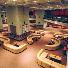 a large room filled with lots of couches and tables on top of carpeted flooring