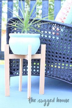 there is a potted plant sitting on a small table next to a chair with legs