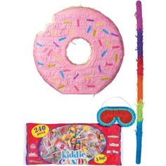 a pink doughnut with sprinkles next to a candy bag and stick