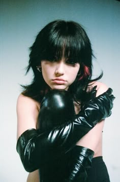 a woman in black leather gloves posing for the camera