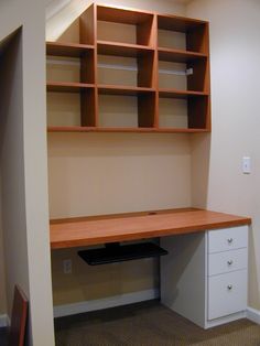 an empty room with a desk and shelves