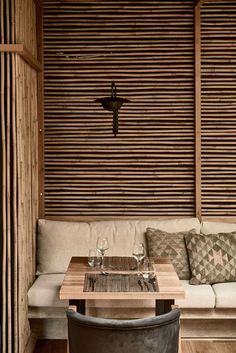 a living room filled with furniture next to a wall covered in wooden slatted walls