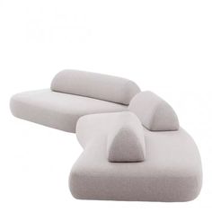 a white couch with two pillows on the back and one seat upholstered to it