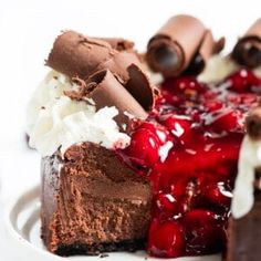 a piece of chocolate cheesecake with cherries and whipped cream