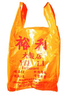 an orange plastic bag with chinese writing on the front and bottom, sitting in front of a white background