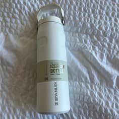 a white bottle sitting on top of a bed