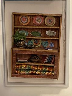 an old wooden shelf with plates on it