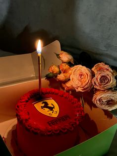 a ferrari cake with roses and a lit candle