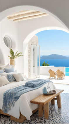 a bed sitting under a window next to a wooden bench and wall with an ocean view