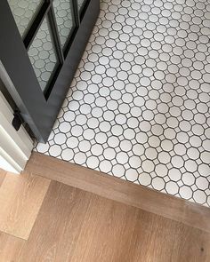 a white and black tiled floor next to a door