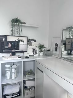 a white desk with two computer monitors on it