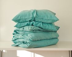 a stack of pillows sitting on top of a white table