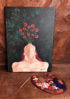 a painting with flowers in it next to a palette