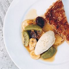 a white plate topped with food next to a fork and knife on top of a table