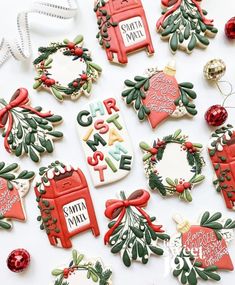 decorated christmas cookies are arranged on a white surface with holiday decorations and ornaments around them