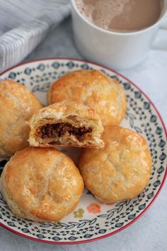 several pastries on a plate next to a cup of coffee